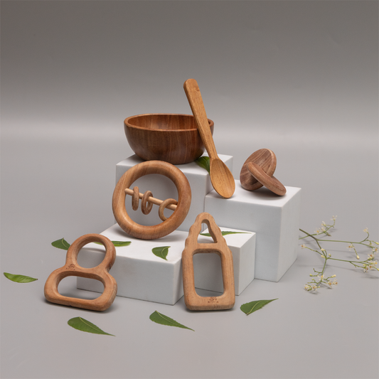 Neem Nurture Kit include interlocking disc , teethers , rattles , bowl and spoon  made  with  neem wood , suggesting an eco-friendly and child-safe environment