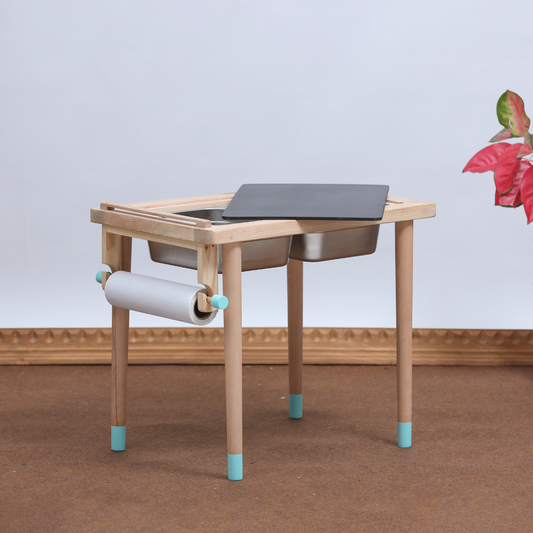 A hand-crafted, foldable sensory table for kids aged 18 months to 7+ years, featuring a blackboard top, dual stainless steel bins, and a built-in art paper roll.