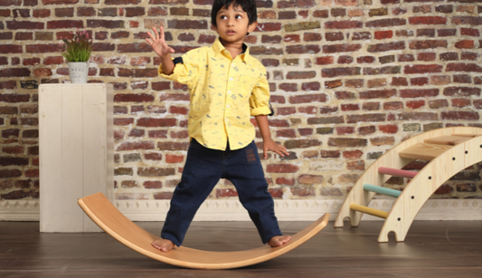 Child standing and balancing on Ariro Wooden Wobble Board