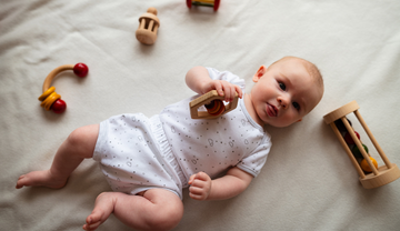 Baby Holding Wooden Rattles
