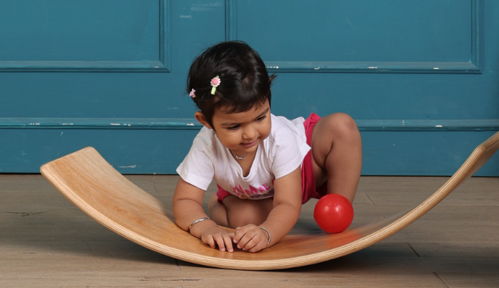 Baby lying on Ariro Wobble Board exploring tactile and sensory input