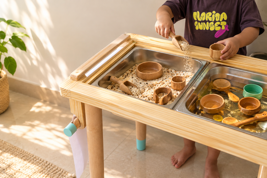 Child playing with wooden scoops and bowls at a sensory table
