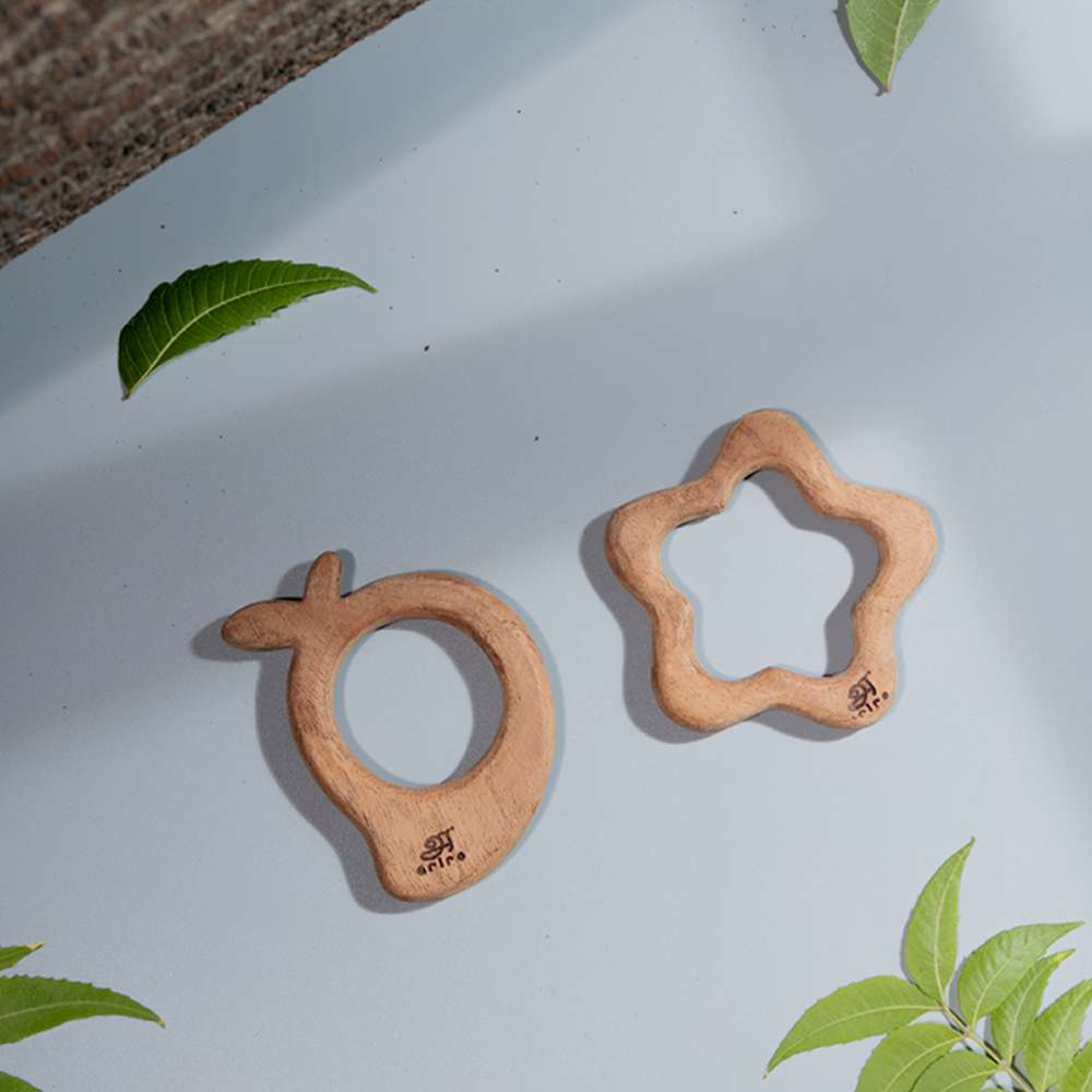 Wooden baby teethers in mango and flower shapes, handcrafted from natural wood for safe and eco-friendly teething made up of neem wood 