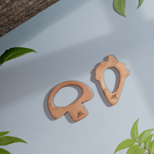 Two wooden baby teethers shaped like a mushroom and a carrot made up of   neem wood.





