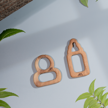 Two wooden baby teethers shaped like a baby figure and a baby bottle ,made  with neem l





