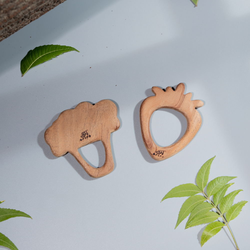  handcrafted wooden teethers shaped like broccoli and a strawberry, designed for easy grip and safe chewing for babies.