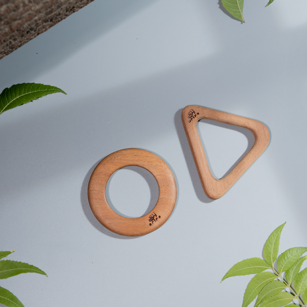 Circular and triangular wooden teethers for babies aged 0 to 2 years.