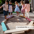 Children playing on Ariro wooden balancing beam demonstrating sturdy construction supporting up to 40 kg weight.