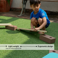 Child lifting Ariro wooden balancing beam plank showing lightweight ergonomic design easy for kids to move and arrange.