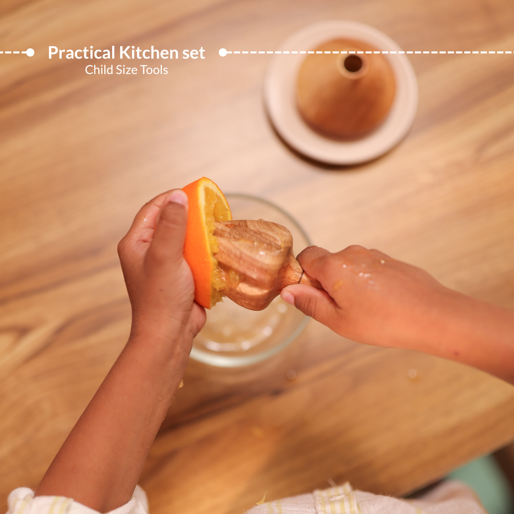 Child using neem wood lemon squeezer from Little Chef’s Montessori practical kitchen set, designed as child-sized tools for hands-on food preparation activities