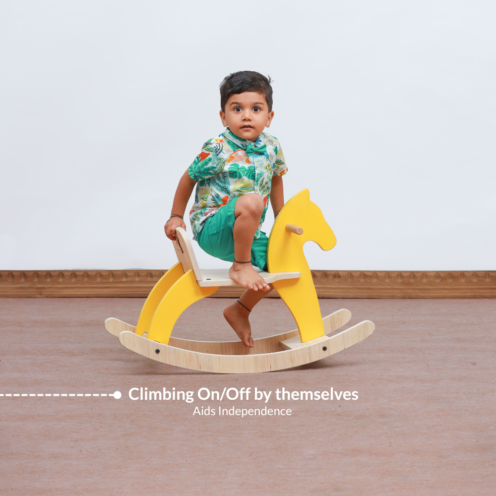 Toddler climbing on Montessori rocking horse independently supporting confidence and self initiated play.