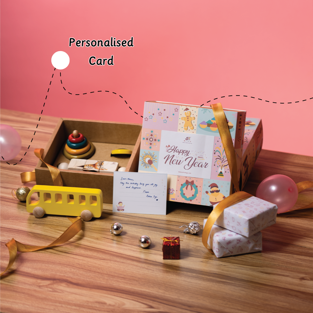 A festive wooden toy gift box labeled “Happy New Year” includes handcrafted toys, a yellow bus, and a personalized message card