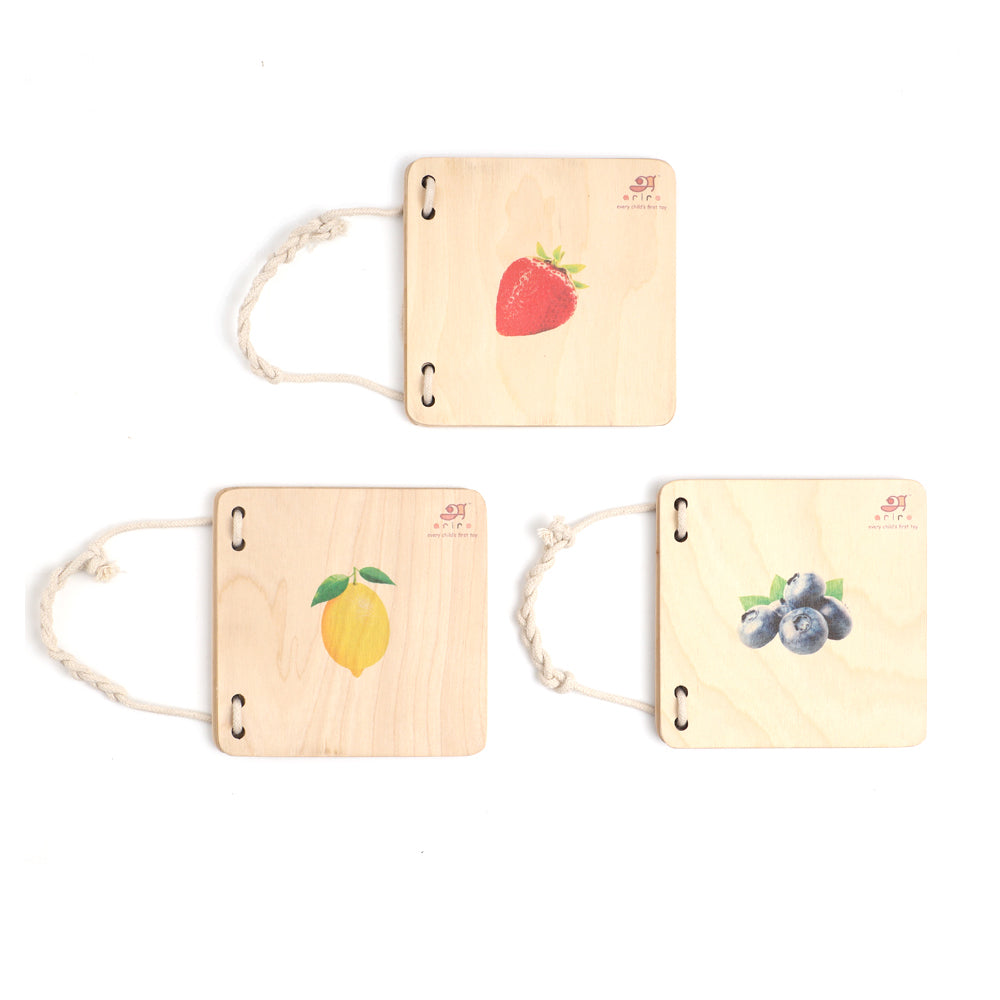 wooden pictorial books  each featuring a different fruit: a strawberry, a lemon, and blueberries.
