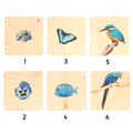wooden puzzle tiles, each depicting a different blue object, such as blueberries, a butterfly, bird , flower , fish  and a macaw.
